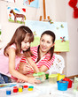 Foto: Child with teacher draw paints in play room. Child with teacher draw paints in play room.