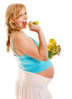 Pregnant woman eating vegetable.