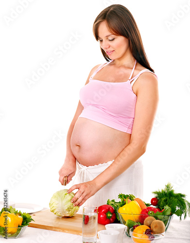 Photo: Pregnant woman preparing food . Pregnant woman preparing food .