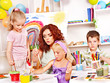 Photo: Child painting at easel. Child painting at easel.