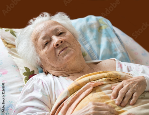 Photo: Old woman lying at bed Old woman lying at bed