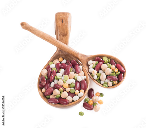 Photo: A mixture of beans in a wooden spoon on a white background A mixture of beans in a wooden spoon on a white background
