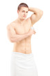 Handsome shirtless man in towel applying anti-perspirant