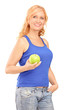 Photo: Middle aged woman holding a green apple and looking at camera Middle aged woman holding a green apple and looking at camera