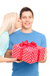Foto: Young woman kissing a man with a present box Young woman kissing a man with a present box