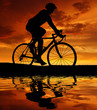 Photo: silhouette of the cyclist riding a road bike at sunset silhouette of the cyclist riding a road bike at sunset