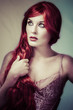 Sexy red haired woman with pink corset and lingerie