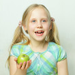 Laughing little girl with green apple