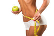 Healthy female body with apple and measuring tape