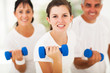 teen girl working out using dumbbell with parents