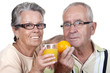 Vieux couple tenant dans la main un verre de jus d'orange et une