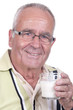Homme âgé avec un verre de lait à la main.