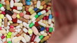 Hand dropping medical pills on heap