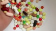 Slow motion of hand dropping medicine pills