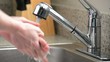Man washes hands in kitchen sink