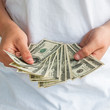 One hundred dollar bills held in a loose fan.