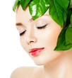 beautiful woman's face, surrounded by green leaves