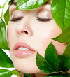 beautiful woman's face, surrounded by green leaves