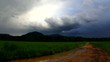 A dirty road to cloudy, stormy afternoon.