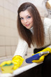  woman cleans bathtub in bathroom