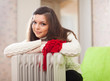 Foto: woman warms near warm heater woman warms near warm heater