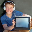 Photo: Cute boy with earphones showing blank tablet screen. Cute boy with earphones showing blank tablet screen.