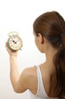 Photo: woman looking at alarm clock, on white background woman looking at alarm clock, on white background