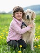 Girl hugging a big dog in an outdoor setting