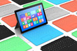 Tablet PC surrounded by colors keyboards.