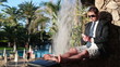 Young businessman using smartphone in exotic resort
