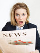 Woman reading newspaper is very surprised