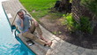 Young man by the pool talking on cellphone