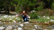 Happy, cheerful girl squirting water from the creek and laughs