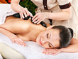 Woman getting stone therapy massage .