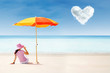 Asian tourist at beach under umbrella and love cloud