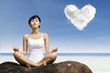 Photo: Asian woman meditating at beach Asian woman meditating at beach