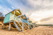 colorful beach huts at sunset