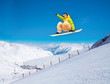 Cute snowboarder man jumping on ski resort