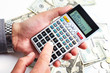 Hand with calculator and money.