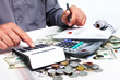 Hand with calculator and money.