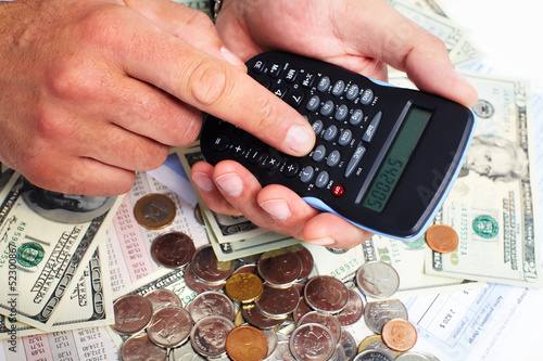 Photo: Hand with calculator and money. Hand with calculator and money.