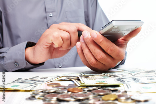 Photo: Hand with calculator and money. Hand with calculator and money.
