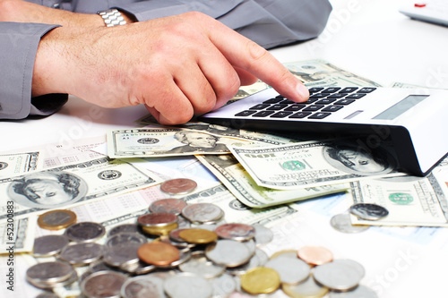 Photo: Hand with calculator and money. Hand with calculator and money.