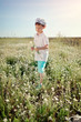 Photo: boy in blue shorts and a cap walks on chamomile field boy in blue shorts and a cap walks on chamomile field