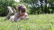 little girl lying on grass and playing with tablet pc