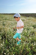 Photo: boy in blue shorts and a cap walks on chamomile field boy in blue shorts and a cap walks on chamomile field