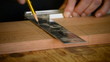 Carpenter or craftsman mark out in a table wood close up