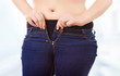 Woman zipping tight jeans, obesity and overweight concept