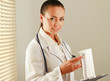 Happy woman is standing near window with folder