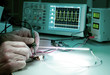 Tech tests electronic equipment in service centre